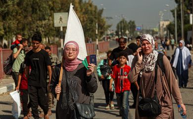 A Palestinian woman holds a white flag while evacuating with a group of civilians from the north of the Gaza Strip towards south, amid the ongoing conflict between Israel and Palestinian Islamist group Hamas, in the central Gaza Strip November 7, 2023. REUTERS/Ahmed Zakot