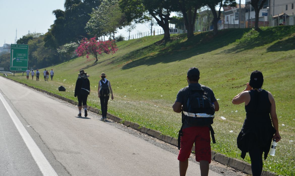 Aparecida (SP) - Romeiros caminham em direção a Aparecida pelo acostamento da Rodovia Dutra, que liga São Paulo ao Rio de Janeiro (Rovena Rosa/Agência Brasil)