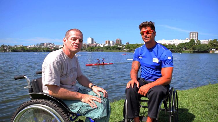 Na beira na Lagoa Rodrigo de Freitas, sentados lado a lado, em cadeiras de rodas, José Luiz Pacheco e Fernando Fernandes.  