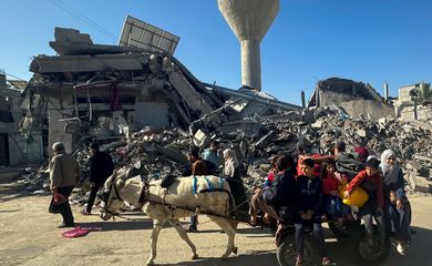 Displaced Palestinians return to their homes as they pass by a house destroyed in an Israeli strike during the conflict, amid the temporary truce between Hamas and Israel, in Khan Younis, in the southern Gaza Strip November 24, 2023. REUTERS/Mohammed Salem