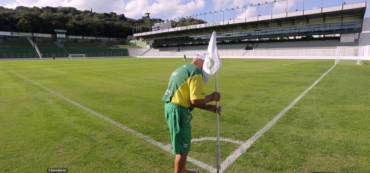 Homem ajeita a bandeira de escanteio em um estádio de futebol