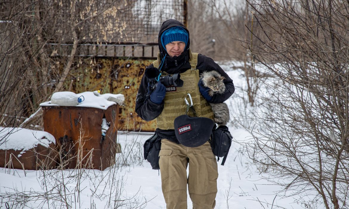 FOTO DE ARCHIVO: El fotógrafo ucraniano Maksim Levin lleva un gato cerca de la línea de separación de los separatistas apoyados por Rusia en la región de Donetsk, Ucrania.