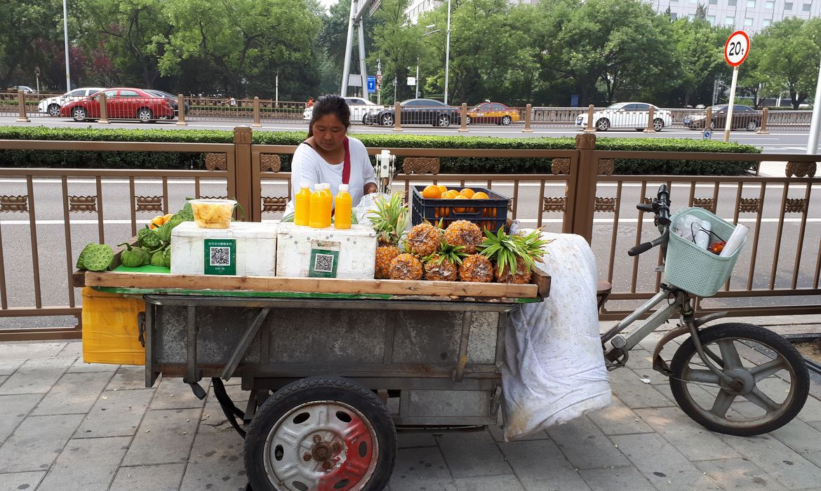 Vendedora de fruta em rua de Pequim tem o QR Code que permite o pagamento por meio do celular