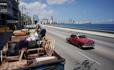 A man loads a truck with furniture from his home prior to the arrival of Storm Elsa, in Havana