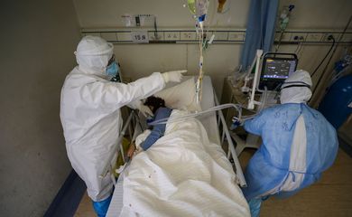 Medical workers in protective suits attend to a patient inside an isolated ward of Wuhan Red Cross Hospital in Wuhan, the epicentre of the novel coronavirus outbreak