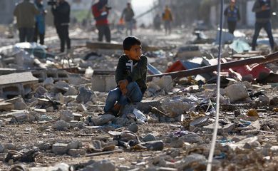 A Palestinian child sits among the rubble of houses destroyed in an Israeli strike during the conflict, as displaced Palestinians return to their homes, amid the temporary truce between Hamas and Israel, in Khan Younis in the southern Gaza Strip November 24, 2023. REUTERS/Ibraheem Abu Mustafa