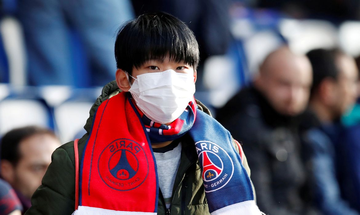 Menino usa máscara de proteção contra coronavírus em jogo do PSG