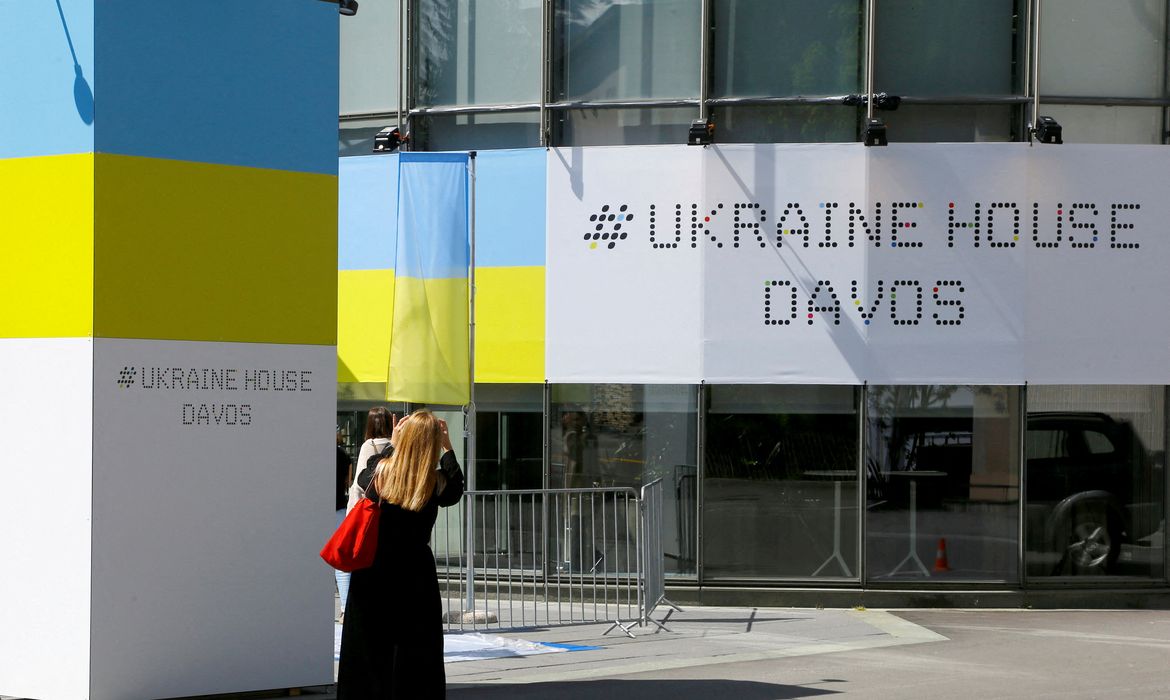 A woman stands in front of the Ukraine House Davos in Davos