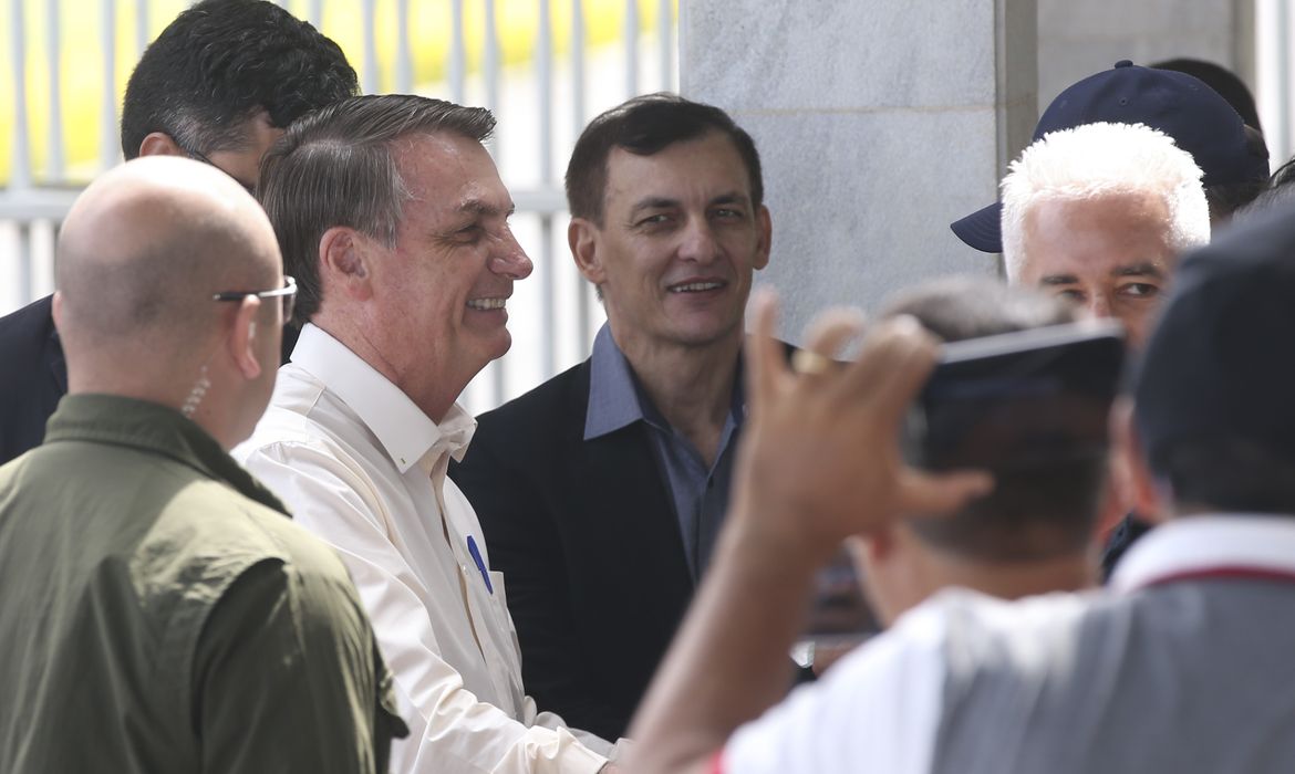 O Presidente Jair Bolsonaro cumprimenta  populares ao sair do Palácio da Alvorada