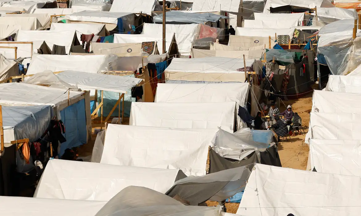 Displaced Palestinians sit by tents, amid the ongoing conflict between Israel and Palestinian Islamist group Hamas, in a tent camp in Khan Younis in the southern Gaza Strip, November 20, 2023. REUTERS/Ibraheem Abu Mustafa