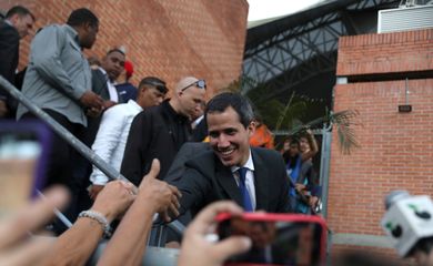 O autoproclamado presidente da Venezuela Juan Guaido deixa o prédio da Assembleia Nacional, em Caracas, e cumprimenta populares