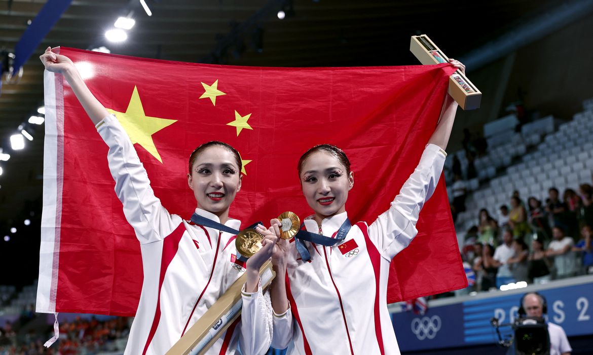 Paris 2024 Olympics - Artistic Swimming - Duet Victory Ceremony - Aquatics Centre, Saint-Denis, France - August 10, 2024. Gold medallists Liuyi Wang of China and Qianyi Wang of China pose for pictures with their medals and the flag of China. REUTERS/Gonzalo Fuentes