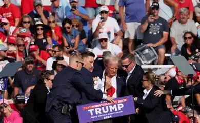 Republican presidential candidate and former U.S. President Donald Trump is assisted by U.S. Secret Service personnel after gunfire rang out during a campaign rally at the Butler Farm Show in Butler, Pennsylvania, U.S., July 13, 2024. REUTERS/Brendan McDermid     TPX IMAGES OF THE DAY