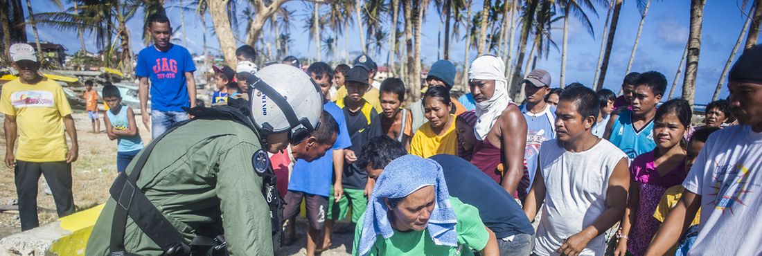 Oficial da marinha americana distribui galões de água potável para os filipinos