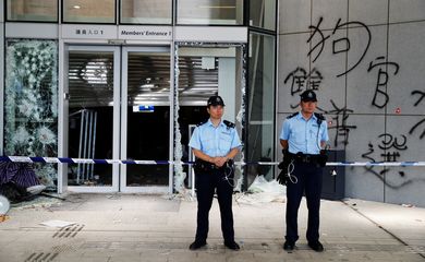 Policemen stand in front of graffiti on the walls of the Legislative Council, a day after protesters broke into the building in Hong Kong, China July 2, 2019.  REUTERS/Jorge Silva